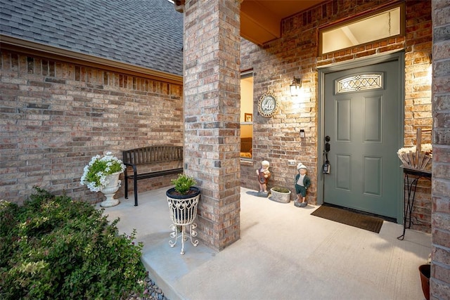 property entrance with brick siding and roof with shingles