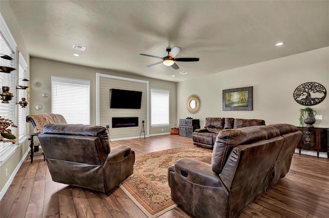 living area featuring visible vents, baseboards, recessed lighting, a fireplace, and hardwood / wood-style flooring