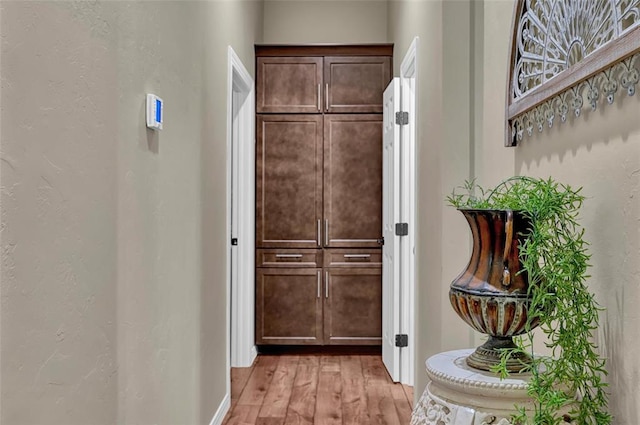 interior space with light wood-style flooring and a textured wall