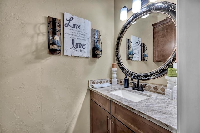 bathroom featuring vanity and a textured wall