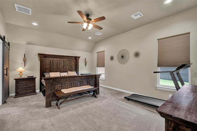 bedroom featuring visible vents, light colored carpet, and a barn door