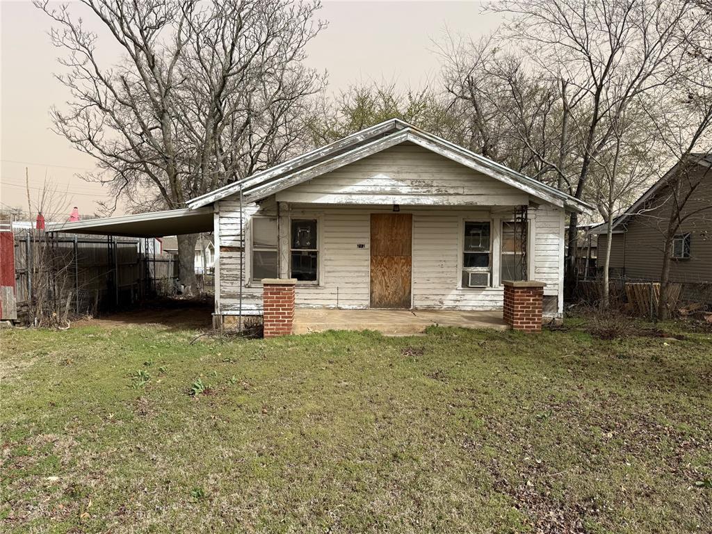 view of front of property featuring an attached carport, cooling unit, a front yard, and fence