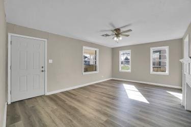 interior space with baseboards, a ceiling fan, and wood finished floors