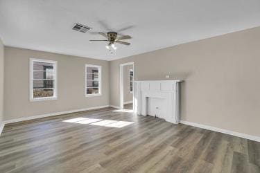 unfurnished living room with visible vents, baseboards, a ceiling fan, and wood finished floors