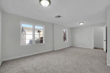 interior space with carpet flooring, baseboards, and visible vents