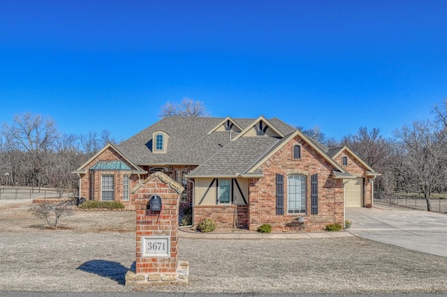 view of front of home with a garage, brick siding, driveway, and roof with shingles