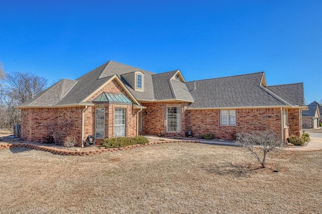 view of front of property with brick siding and a shingled roof