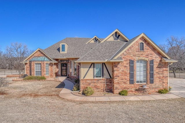 view of front of house featuring brick siding and a shingled roof