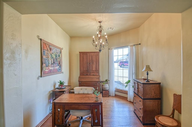 office with visible vents, baseboards, an inviting chandelier, and wood finished floors