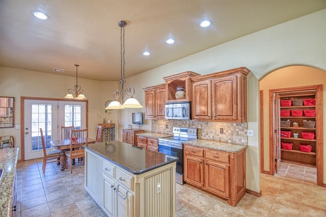 kitchen with decorative backsplash, dark stone countertops, stainless steel appliances, and visible vents