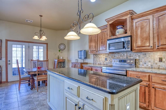 kitchen featuring tasteful backsplash, visible vents, dark stone countertops, and stainless steel appliances