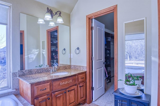 bathroom with a spacious closet and vanity