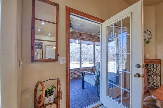 doorway to outside featuring carpet and a ceiling fan