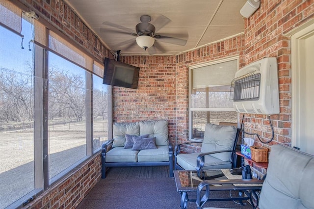 unfurnished sunroom featuring a ceiling fan and a wall mounted AC