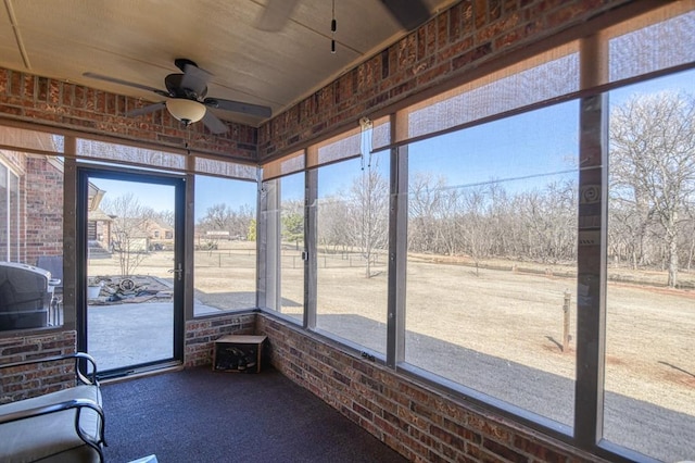 unfurnished sunroom with plenty of natural light and a ceiling fan