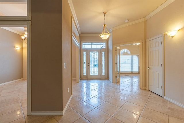 foyer with crown molding, light tile patterned floors, and baseboards