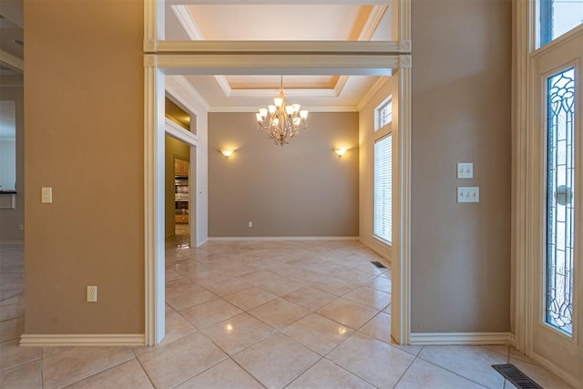 entryway with visible vents, a tray ceiling, crown molding, light tile patterned floors, and a chandelier