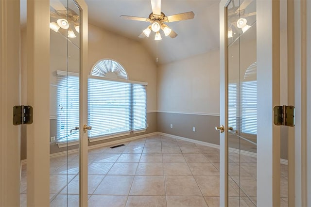 unfurnished room featuring visible vents, ceiling fan, vaulted ceiling, french doors, and tile patterned floors