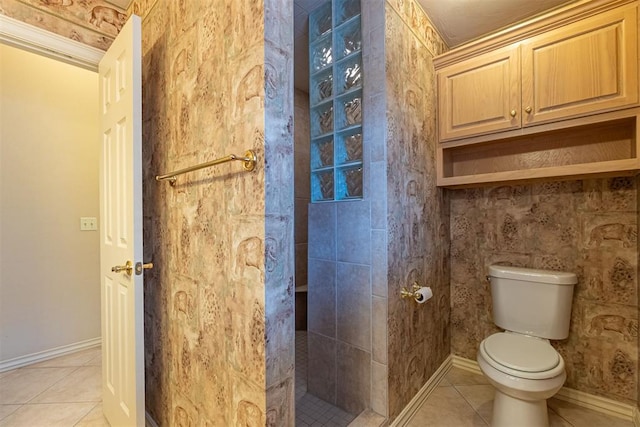 full bathroom with tiled shower, baseboards, toilet, and tile patterned flooring