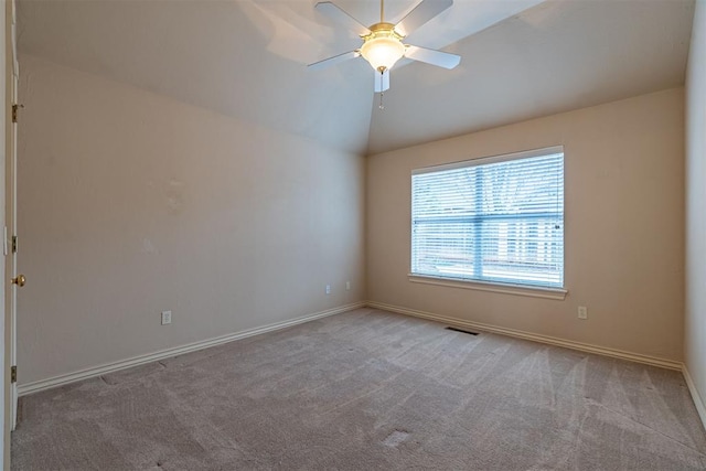 carpeted empty room with lofted ceiling, baseboards, visible vents, and ceiling fan