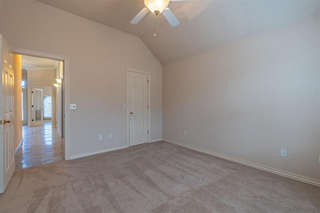 unfurnished bedroom with light tile patterned floors, baseboards, lofted ceiling, ceiling fan, and light carpet