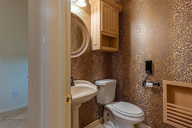 half bath featuring tile patterned floors, baseboards, toilet, and wallpapered walls