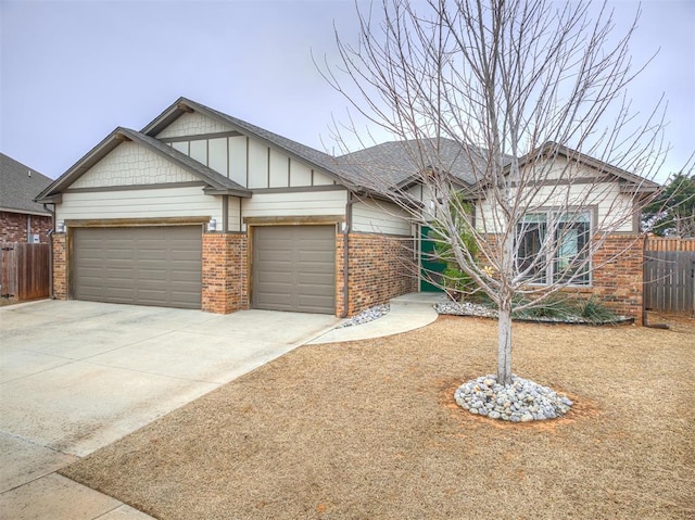 view of front of home featuring concrete driveway, an attached garage, fence, and brick siding