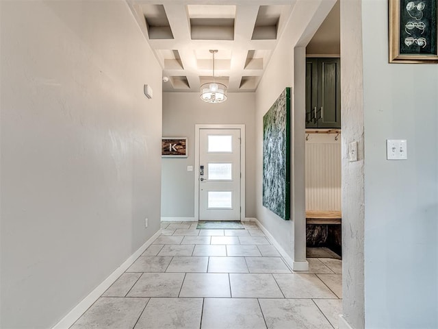 entrance foyer featuring a notable chandelier, baseboards, coffered ceiling, and a towering ceiling