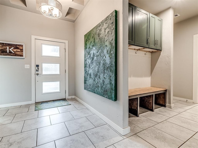 foyer featuring light tile patterned floors, baseboards, and a chandelier