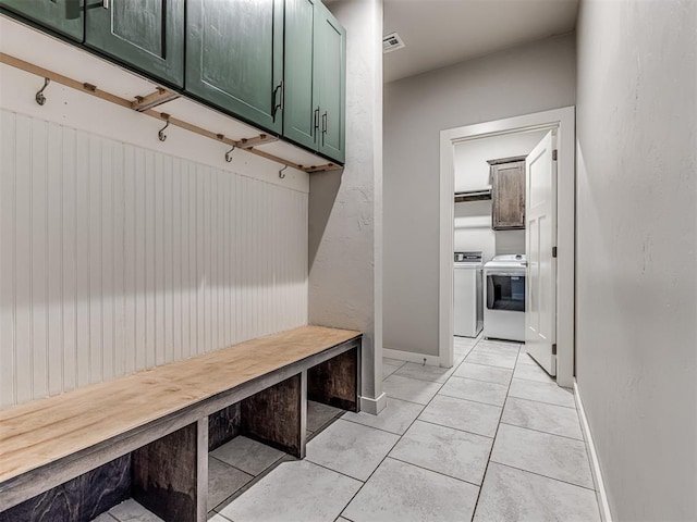 mudroom with light tile patterned floors, visible vents, independent washer and dryer, and baseboards