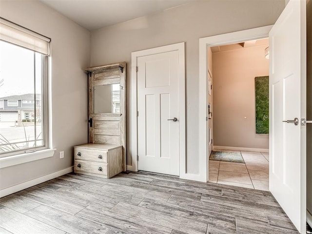 unfurnished bedroom featuring light wood-type flooring and baseboards