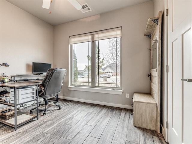 office area with a ceiling fan, wood finished floors, visible vents, and baseboards