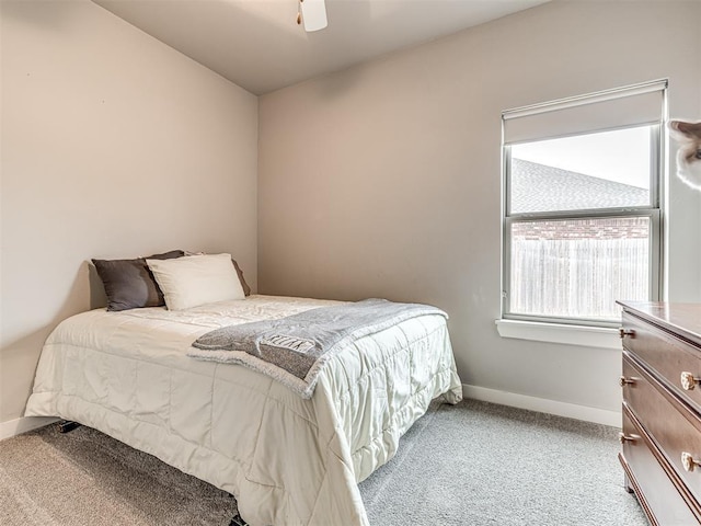 bedroom featuring baseboards, light colored carpet, and a ceiling fan