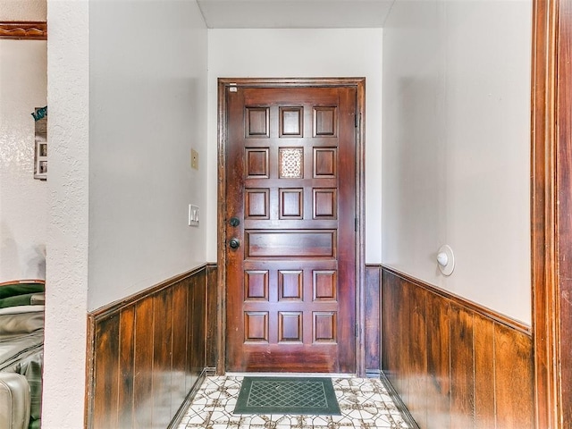 foyer with wooden walls and a wainscoted wall