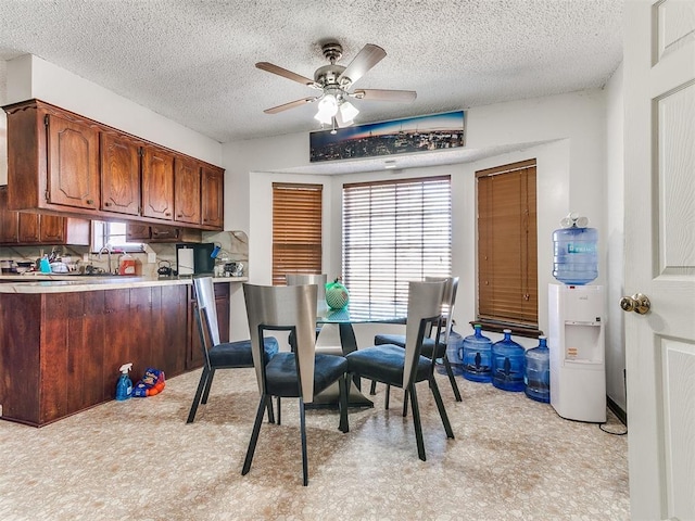 dining space featuring a ceiling fan and a textured ceiling