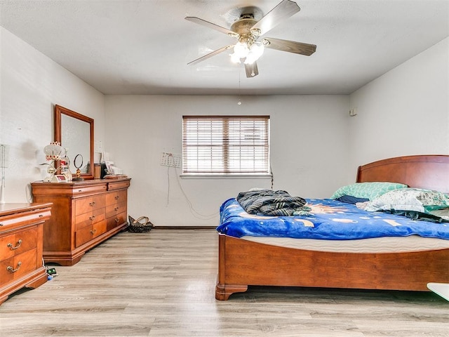 bedroom featuring baseboards, a ceiling fan, and light wood-style floors