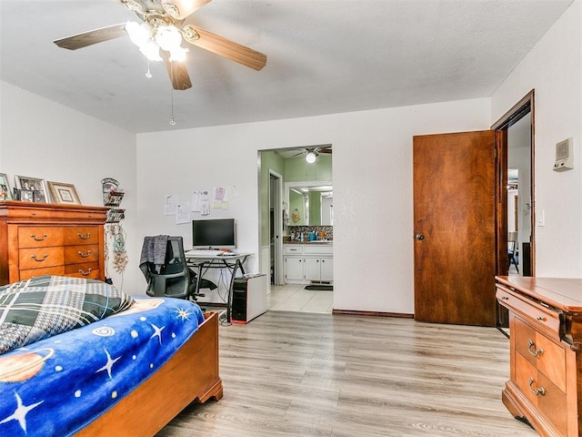 bedroom featuring light wood finished floors, connected bathroom, and a ceiling fan