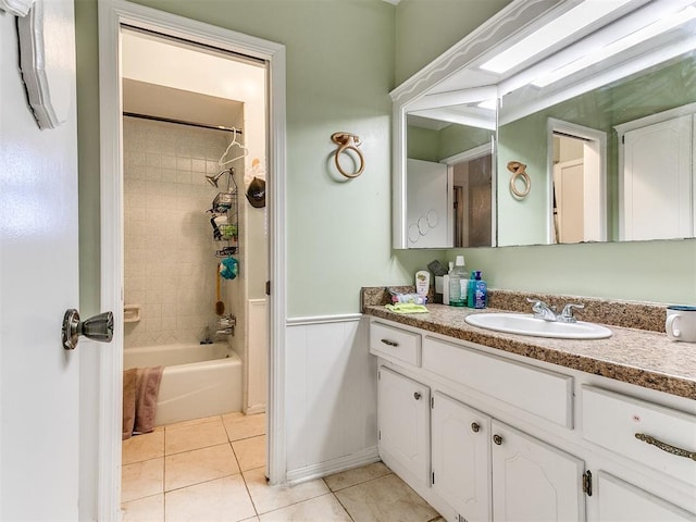 full bath with tile patterned flooring, vanity, tub / shower combination, and wainscoting