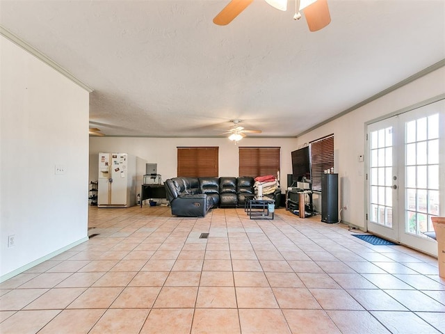 unfurnished living room featuring ornamental molding, light tile patterned floors, french doors, a textured ceiling, and a ceiling fan