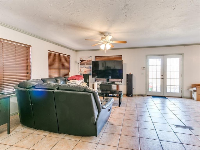 living room featuring light tile patterned floors, ceiling fan, french doors, a textured ceiling, and crown molding