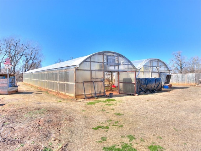 view of yard featuring a greenhouse and an outbuilding