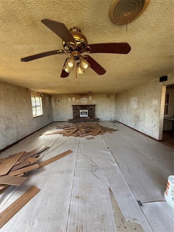 unfurnished living room featuring a textured ceiling, a fireplace, and ceiling fan