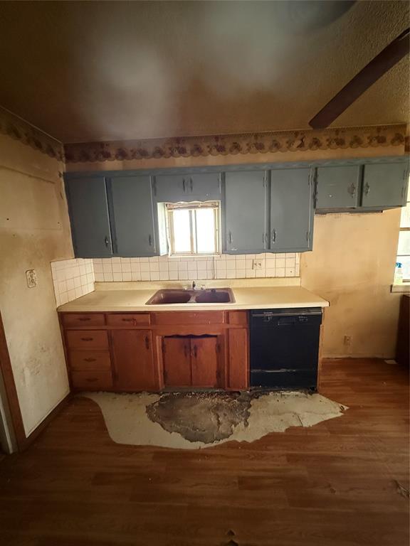 kitchen with a sink, light countertops, light wood-style floors, dishwasher, and tasteful backsplash