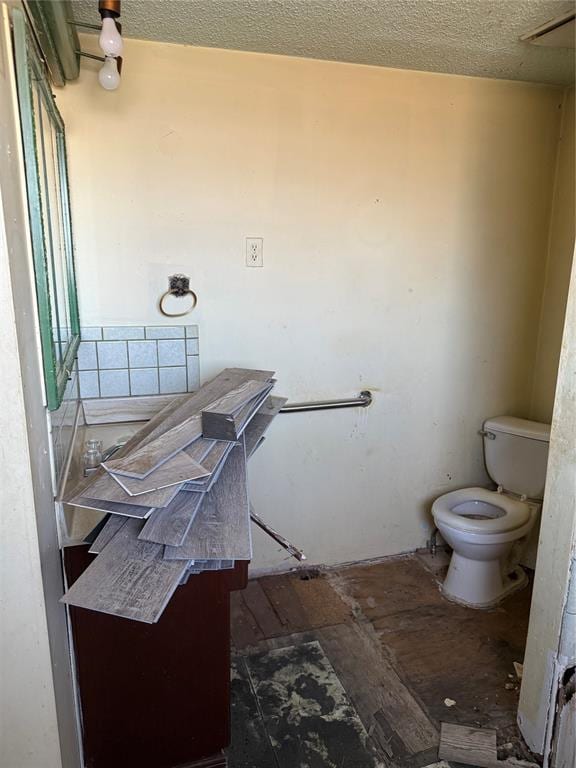 bathroom with vanity, toilet, and a textured ceiling