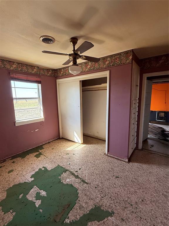 unfurnished bedroom with visible vents, a closet, and ceiling fan