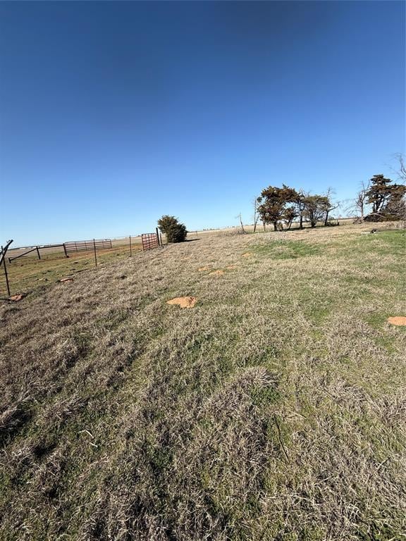 view of yard featuring a rural view and fence