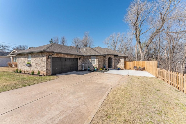 view of front facade with brick siding, a front lawn, fence, concrete driveway, and a garage