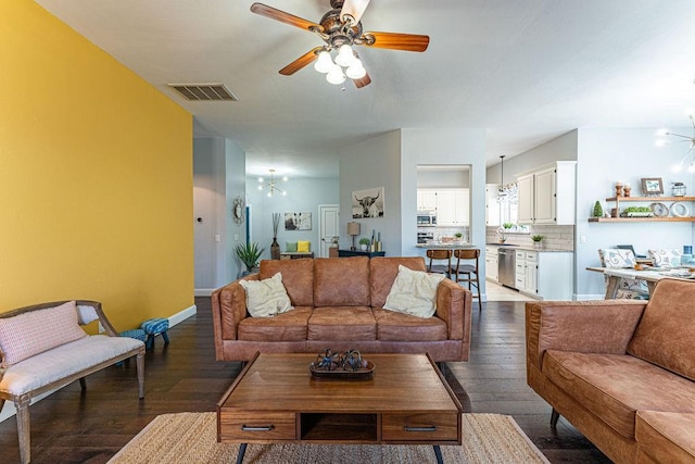 living area featuring wood finished floors, a ceiling fan, visible vents, and baseboards