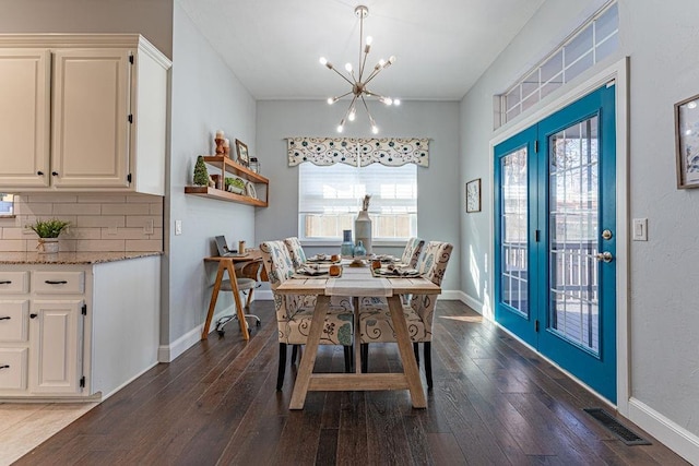 dining area with visible vents, baseboards, dark wood-type flooring, and an inviting chandelier