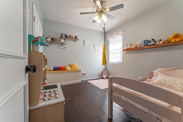 bedroom with dark wood finished floors, a ceiling fan, and baseboards